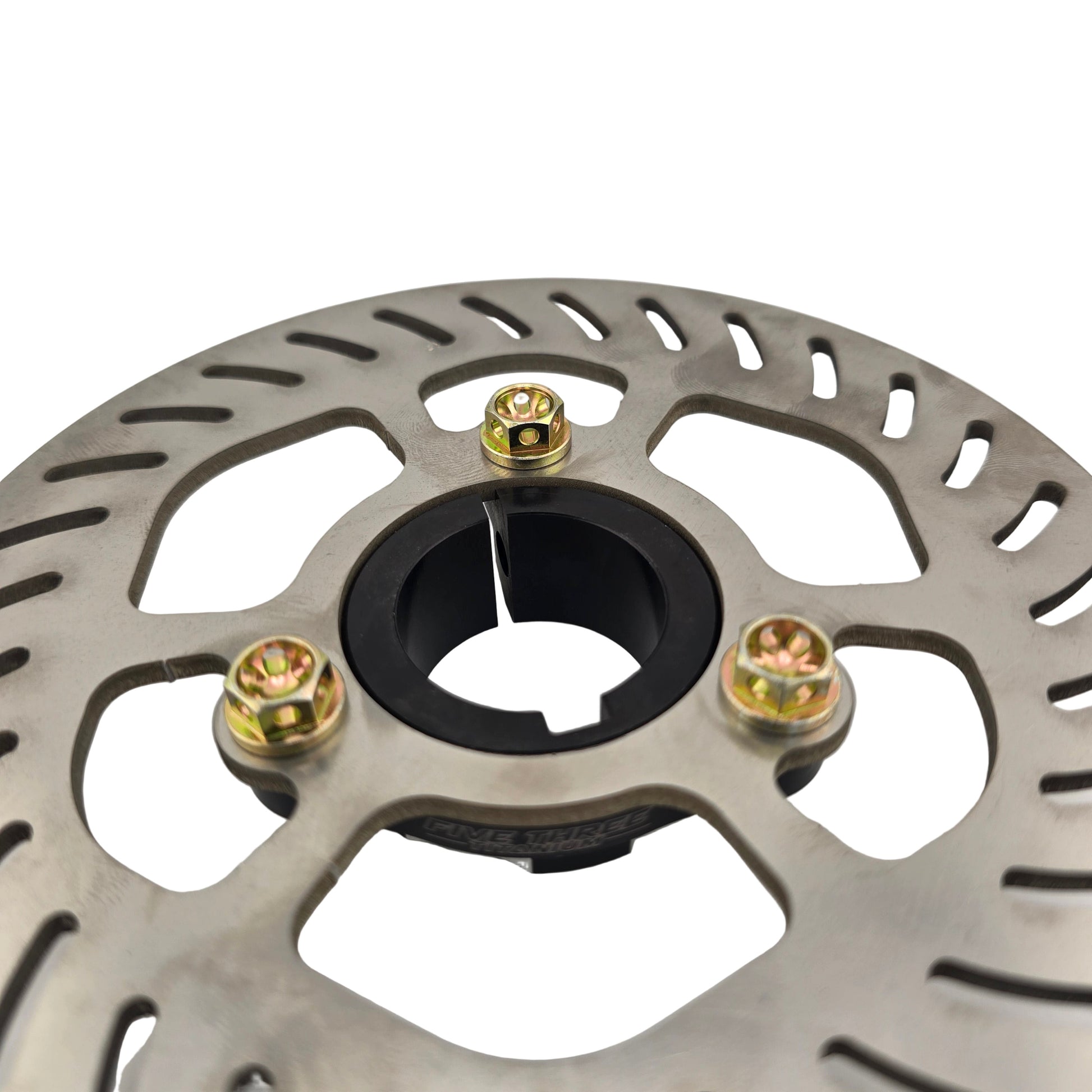 Close-up of a metallic brake disc with gold screws on a light gray background